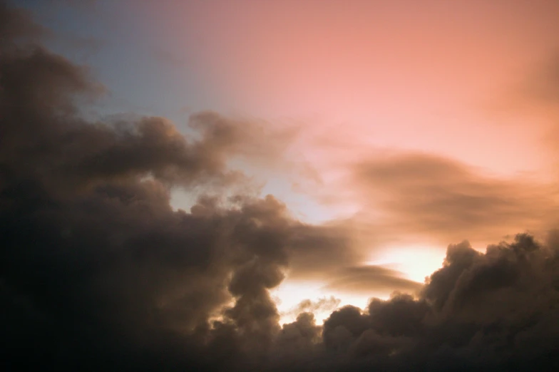 clouds and a plane silhouetted in the sunset