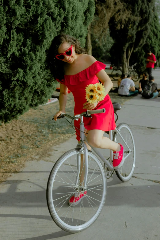 a woman in red dress on bike next to street