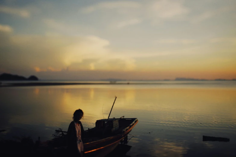 a person standing next to a boat on top of a body of water