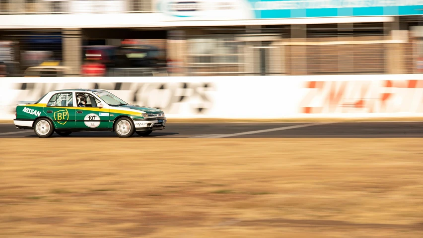 this is a green and yellow minibus on a race track