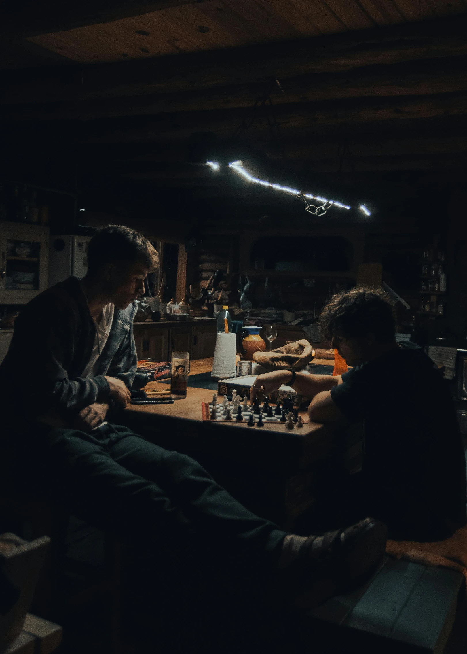 two people playing chess in a dark room