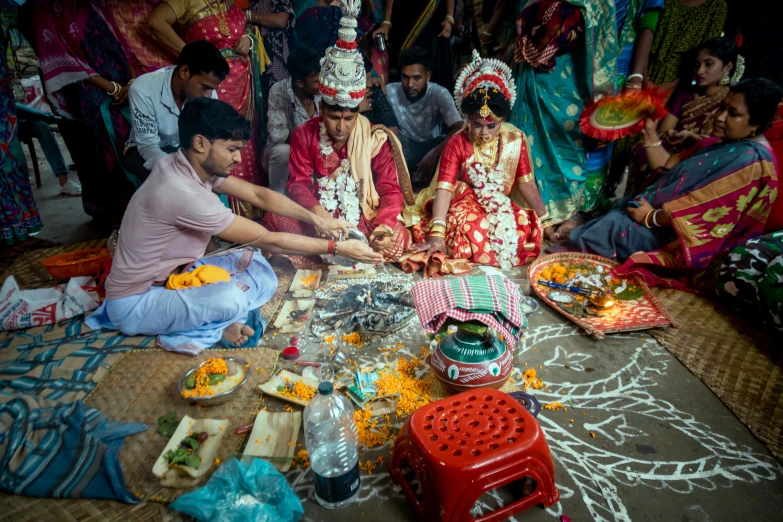 a man sitting next to two women at a table in front of a tablecloth