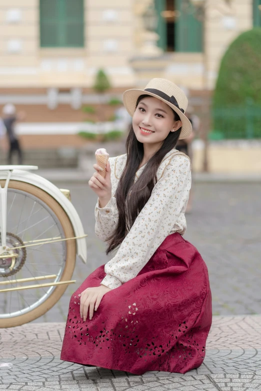 the woman poses while kneeling next to her bike