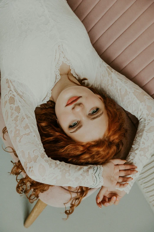 a young woman with a lace dress is laying on a bed