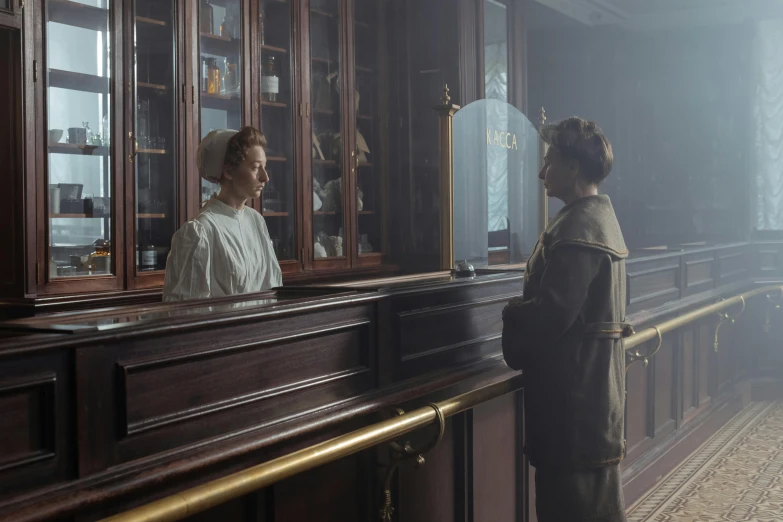 two people standing behind a bar in a room