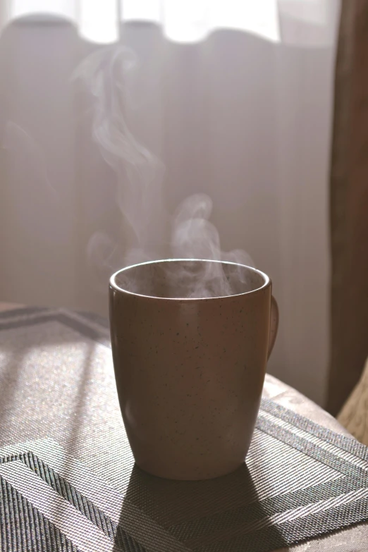 steam rising from a cup on a table