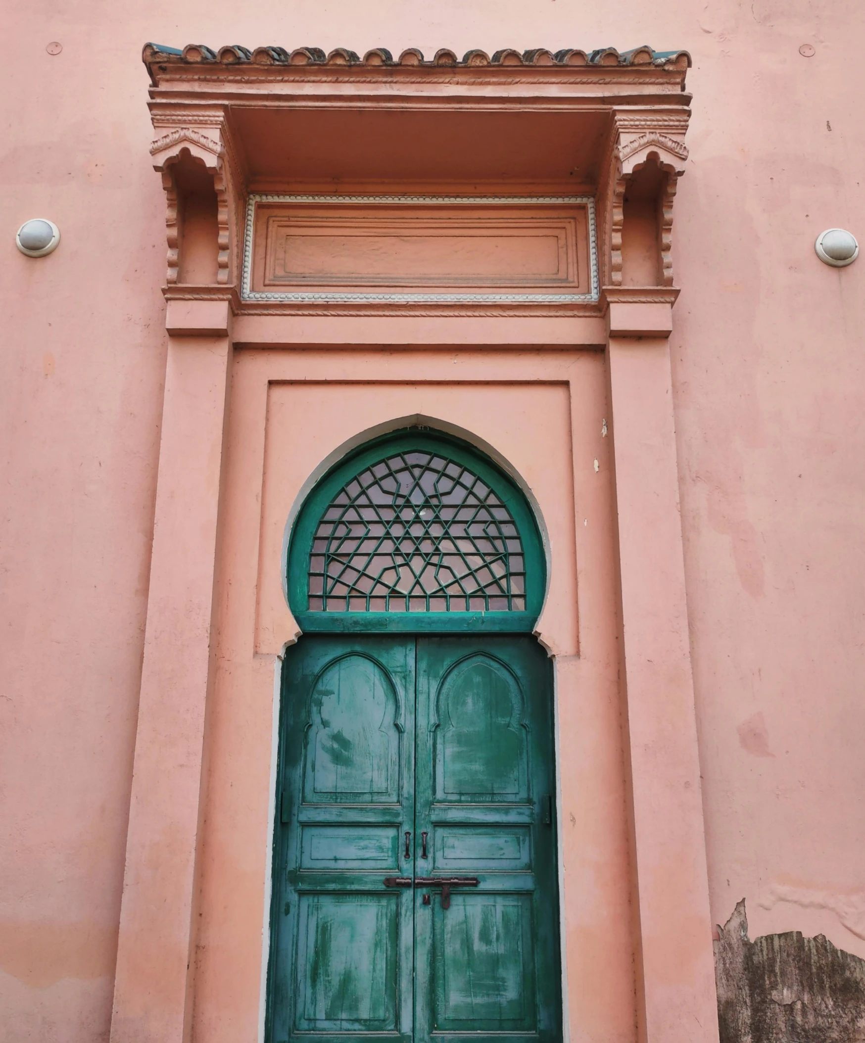 a green door surrounded by windows and wall