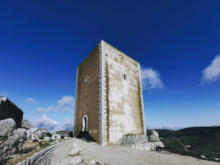 a very tall and white building on a mountain side