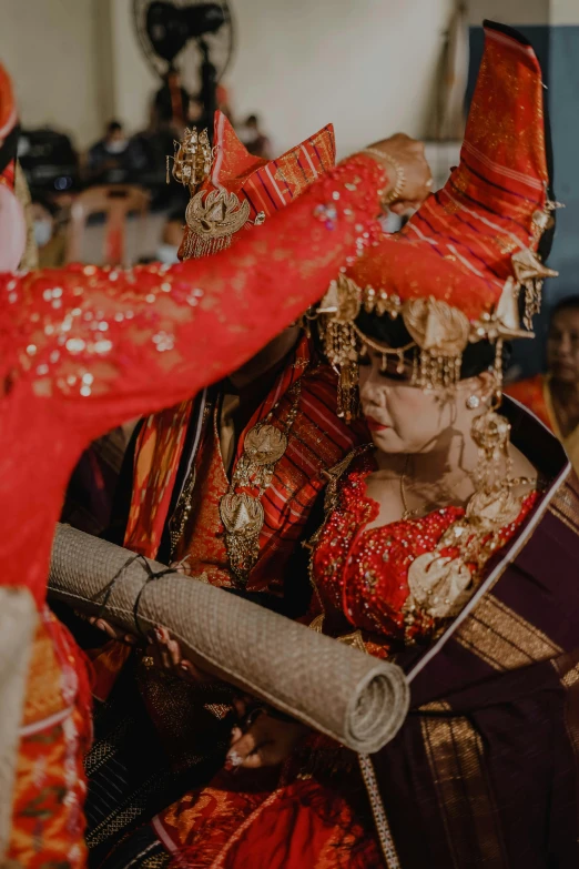 a man and woman dressed in red with red ribbons