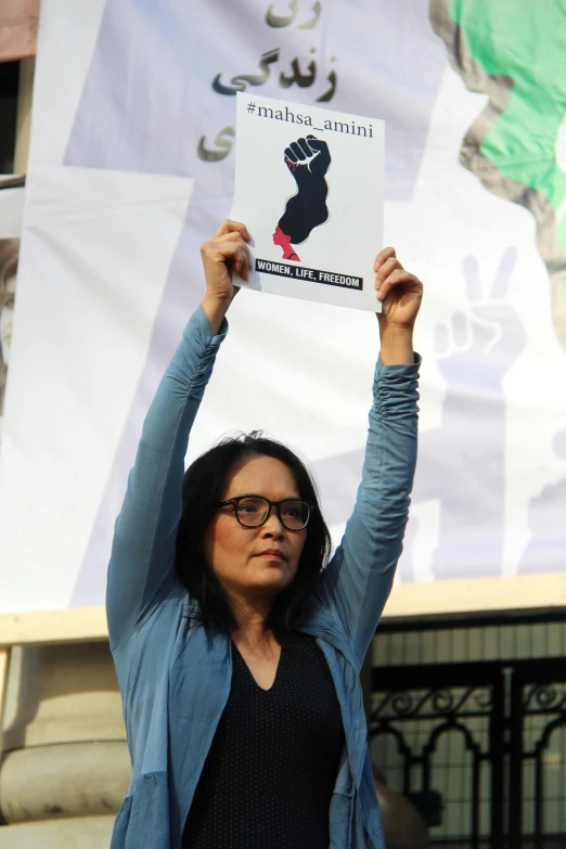 a woman holds up a sign to say protest