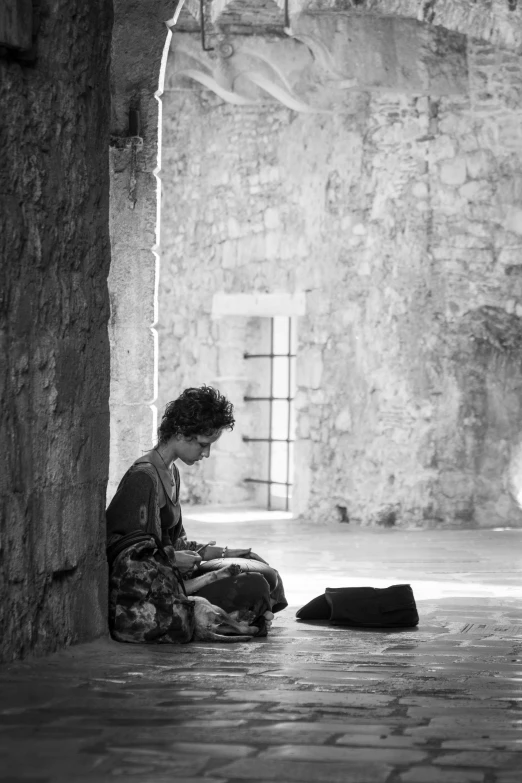 a woman sitting on the ground looking at her cell phone