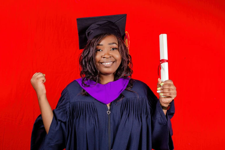 a young woman with a cap, gown and a tassel holds a diploma