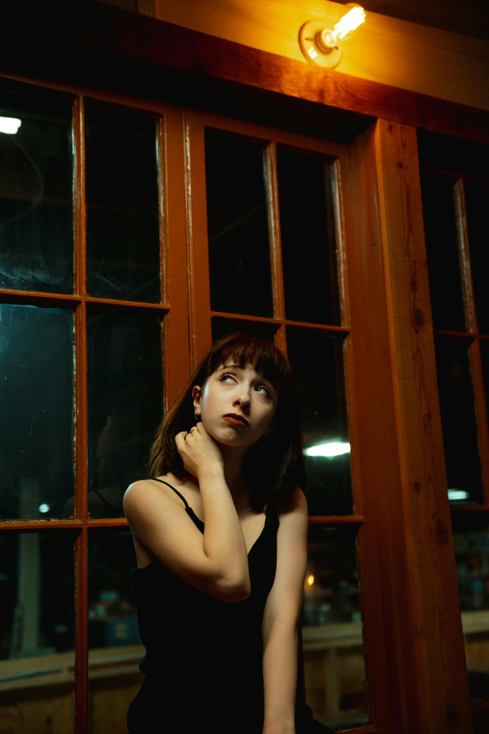 a woman looking out a window at night