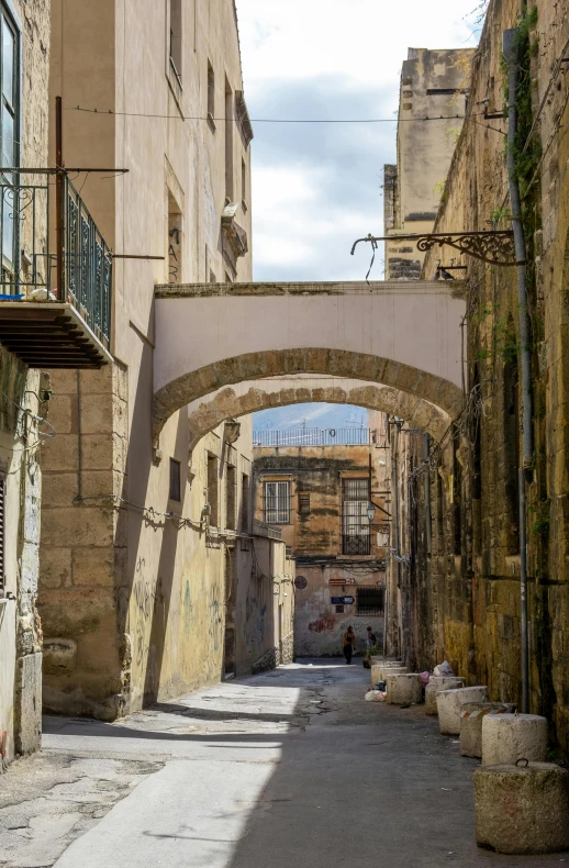 a narrow alleyway has arched arches above