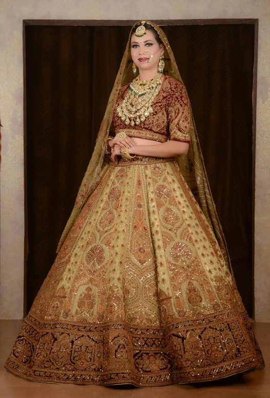 bride in a gold and gold lehenga posing for a picture