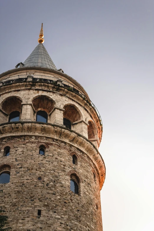 the top of an old tower made from brick with a clock displayed