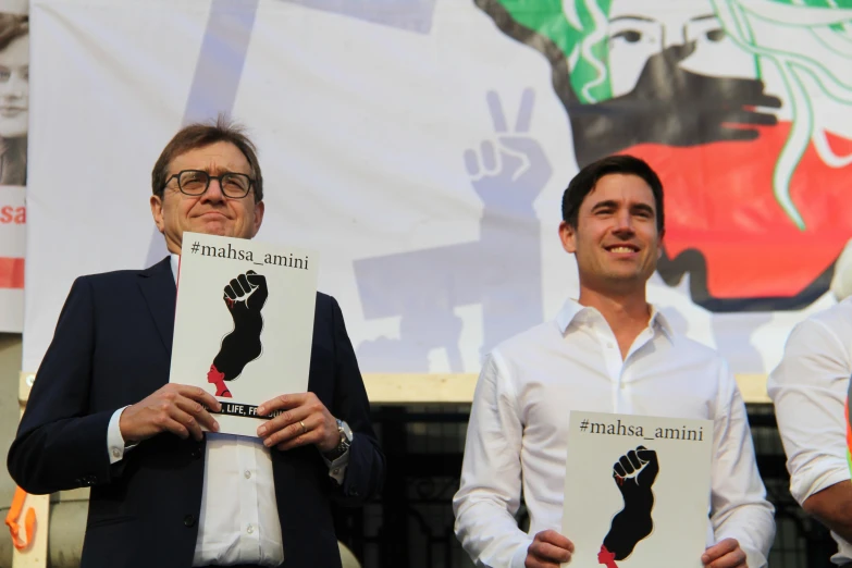 two men holding up signs in front of them