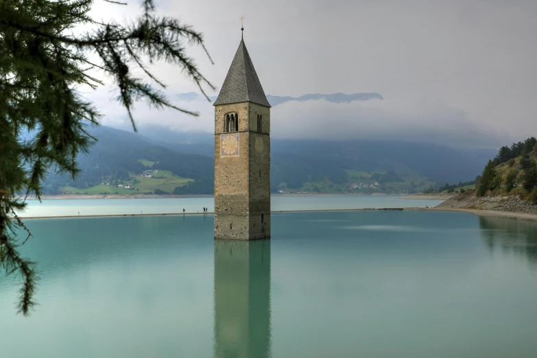 an image of a very tall building with a lake and hills