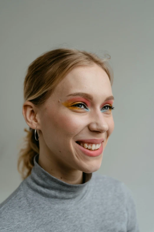 a woman with a smile and orange eyeshadow