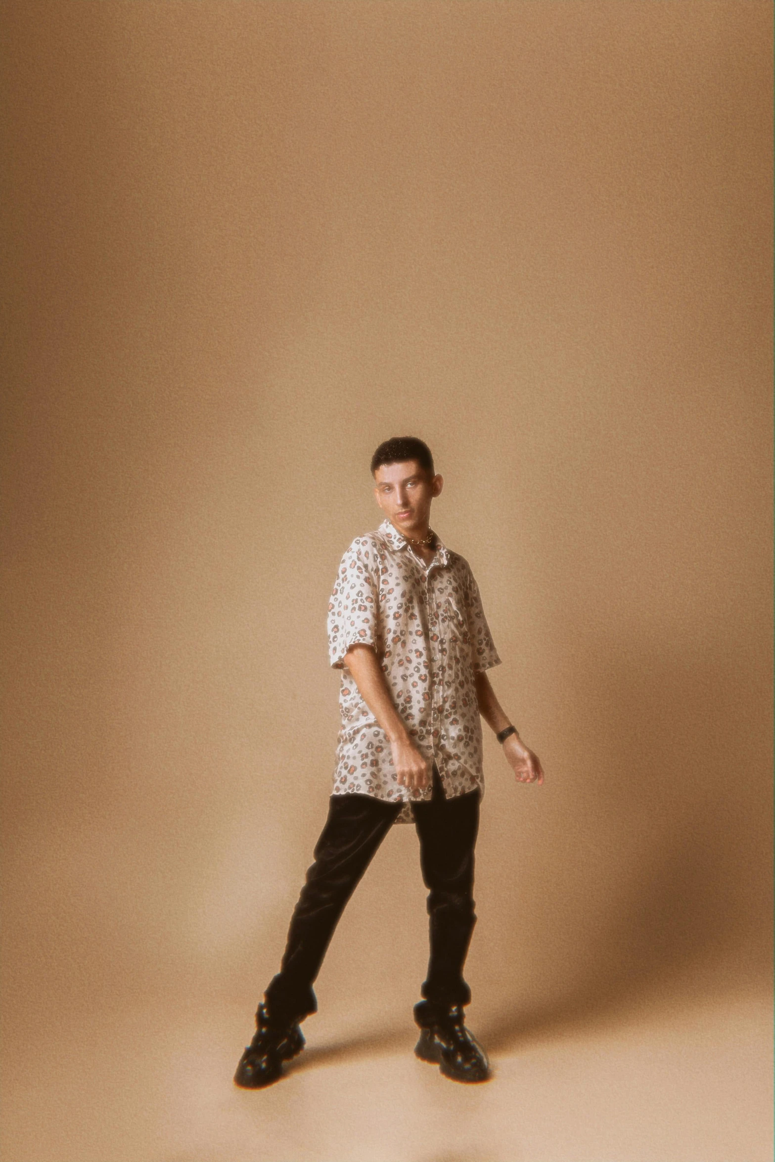 the young man is standing in front of a beige background