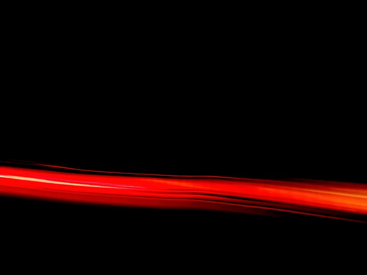 a blurry red object with a black background