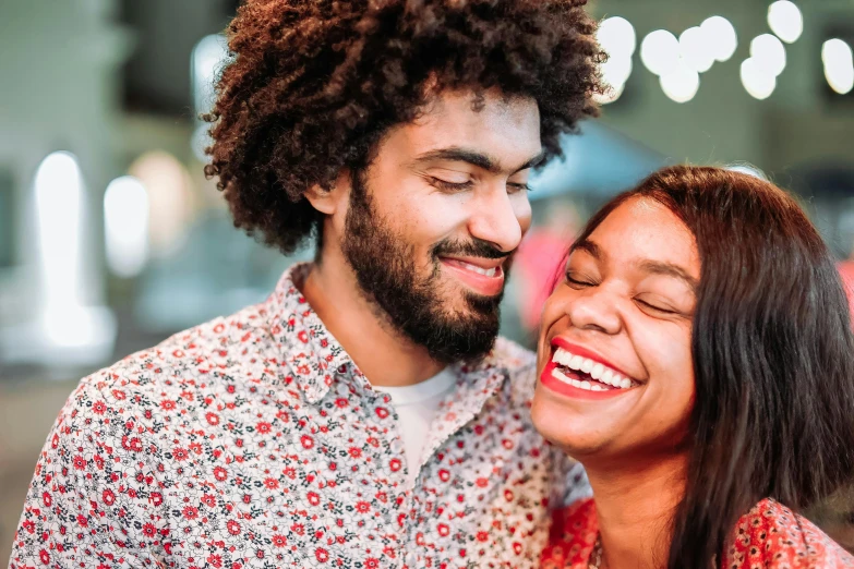 a young man and woman laughing together in the night