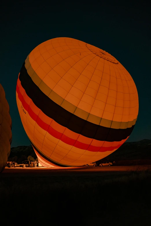 an orange and black  air balloon is shining