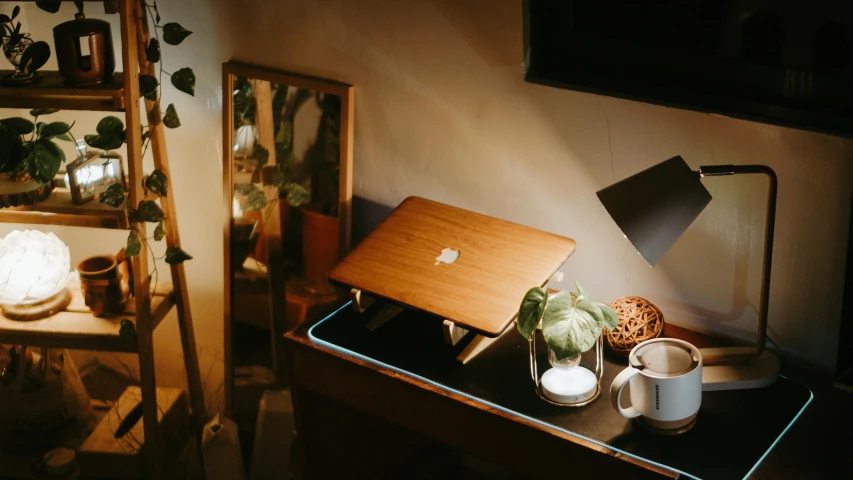 a desk with a laptop and cup on it