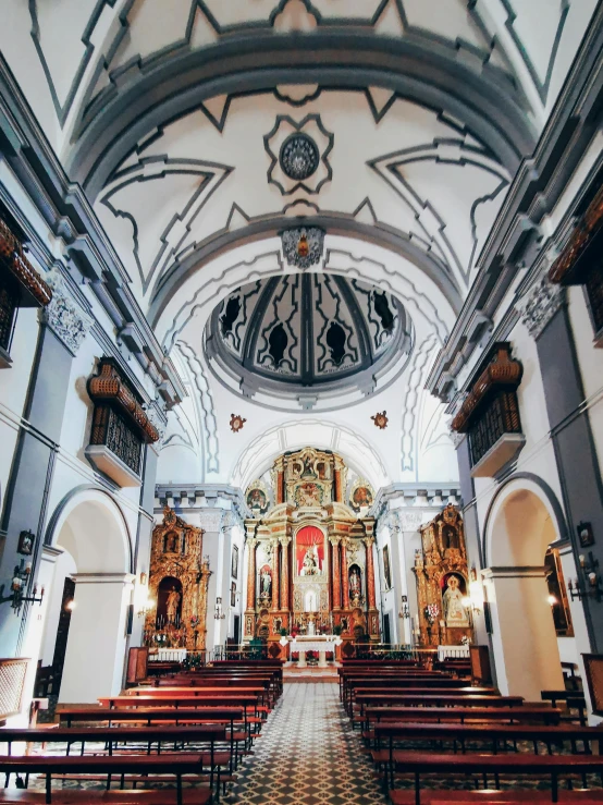 a church with high ceiling and wooden pews