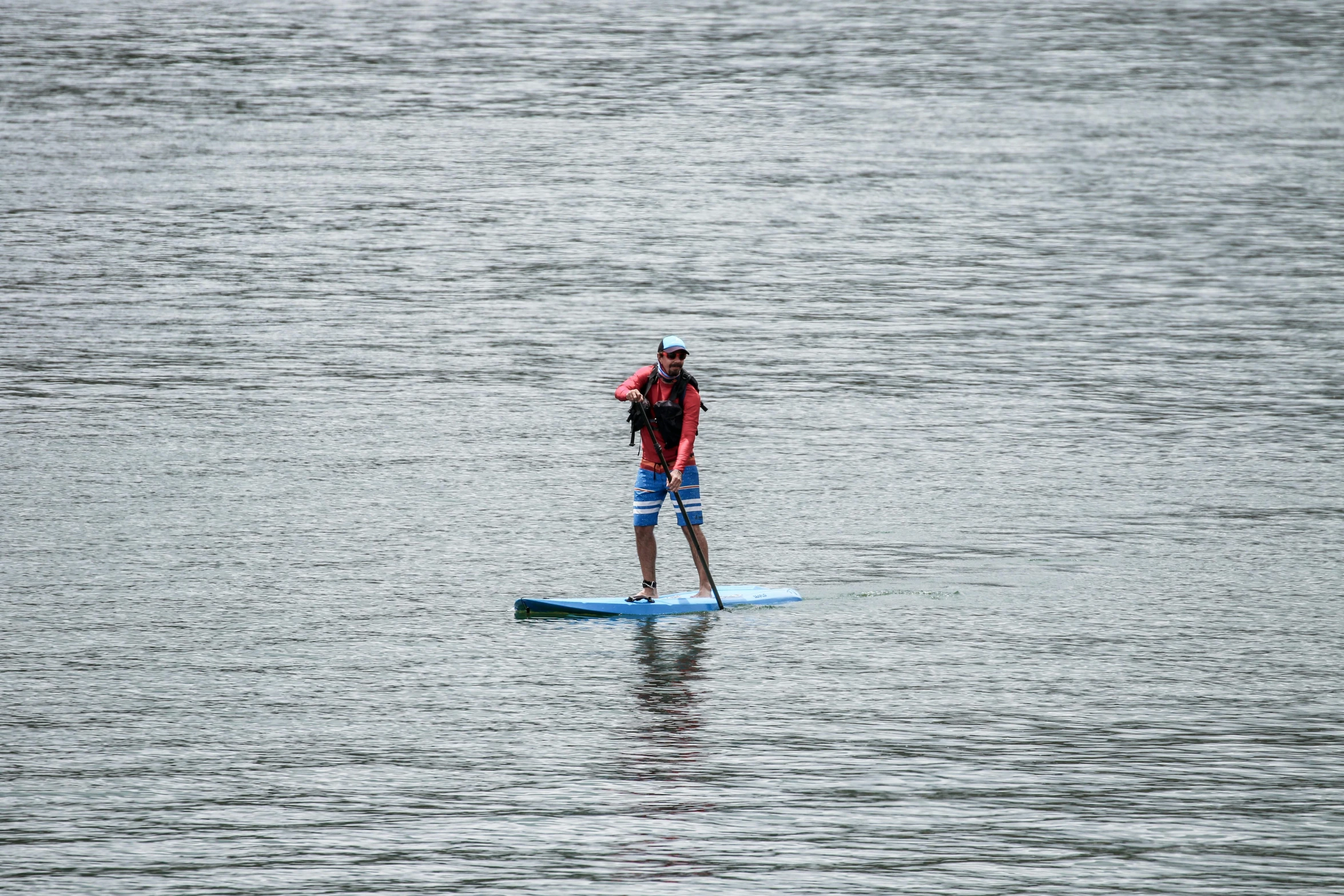 a man riding on top of a blue surfboard