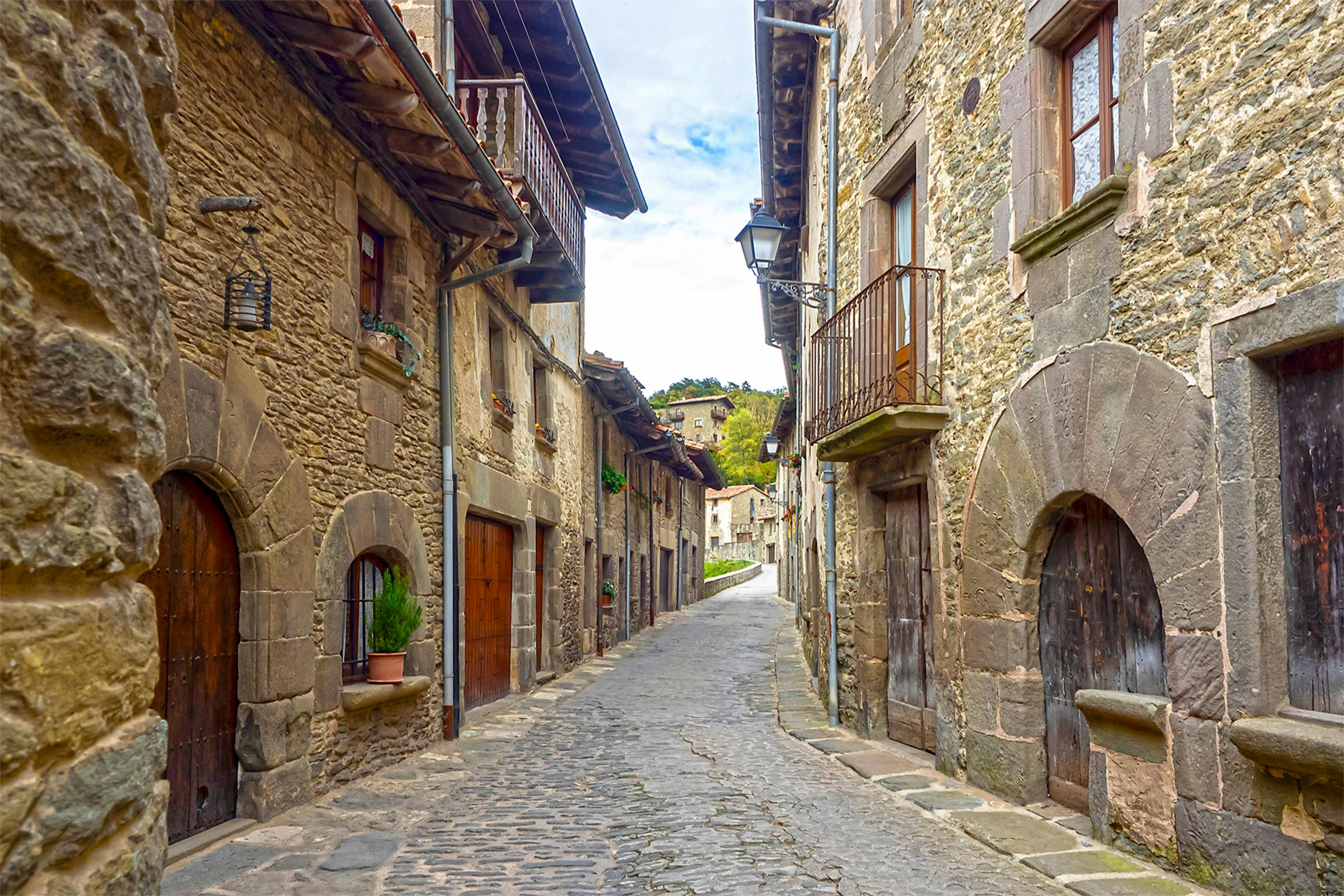 an empty street is shown in stone buildings