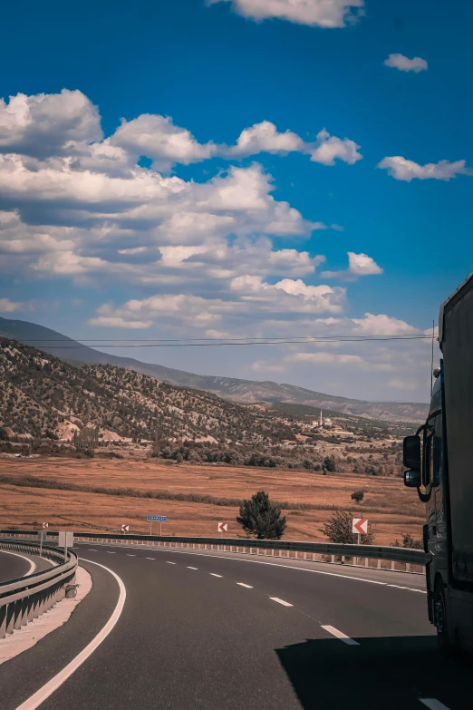 a truck is going down the road on a windy day