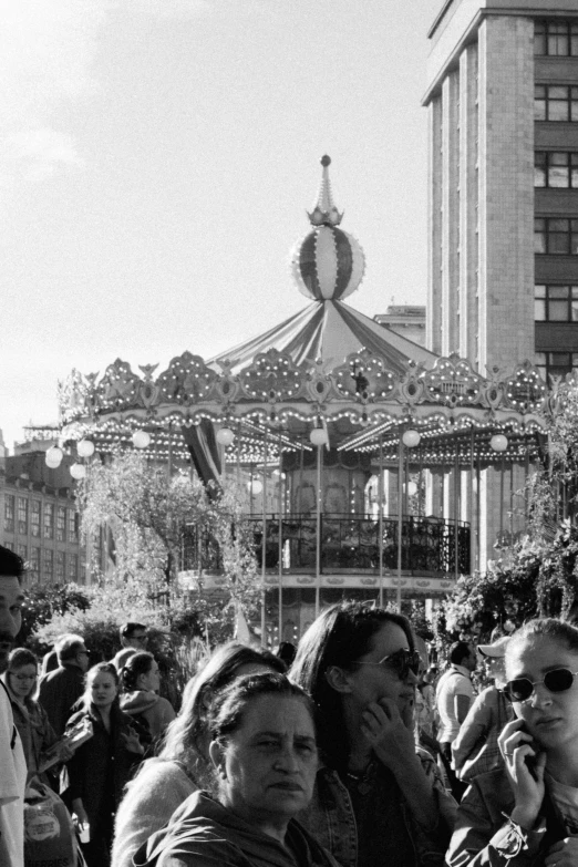 several people in a city and a carousel