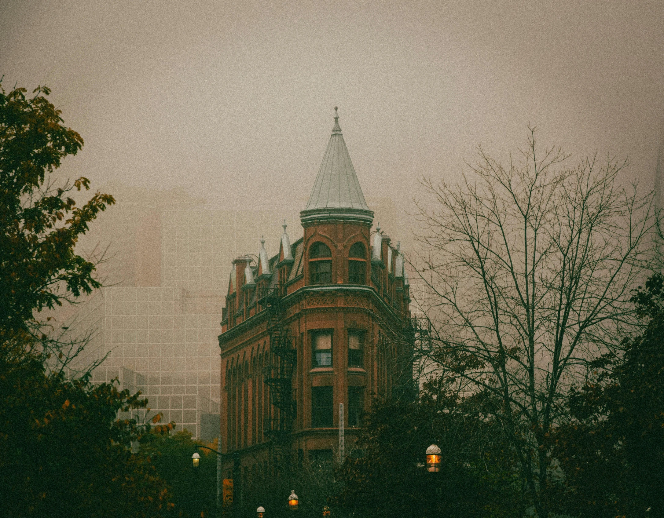 people walk in the distance in front of an old building