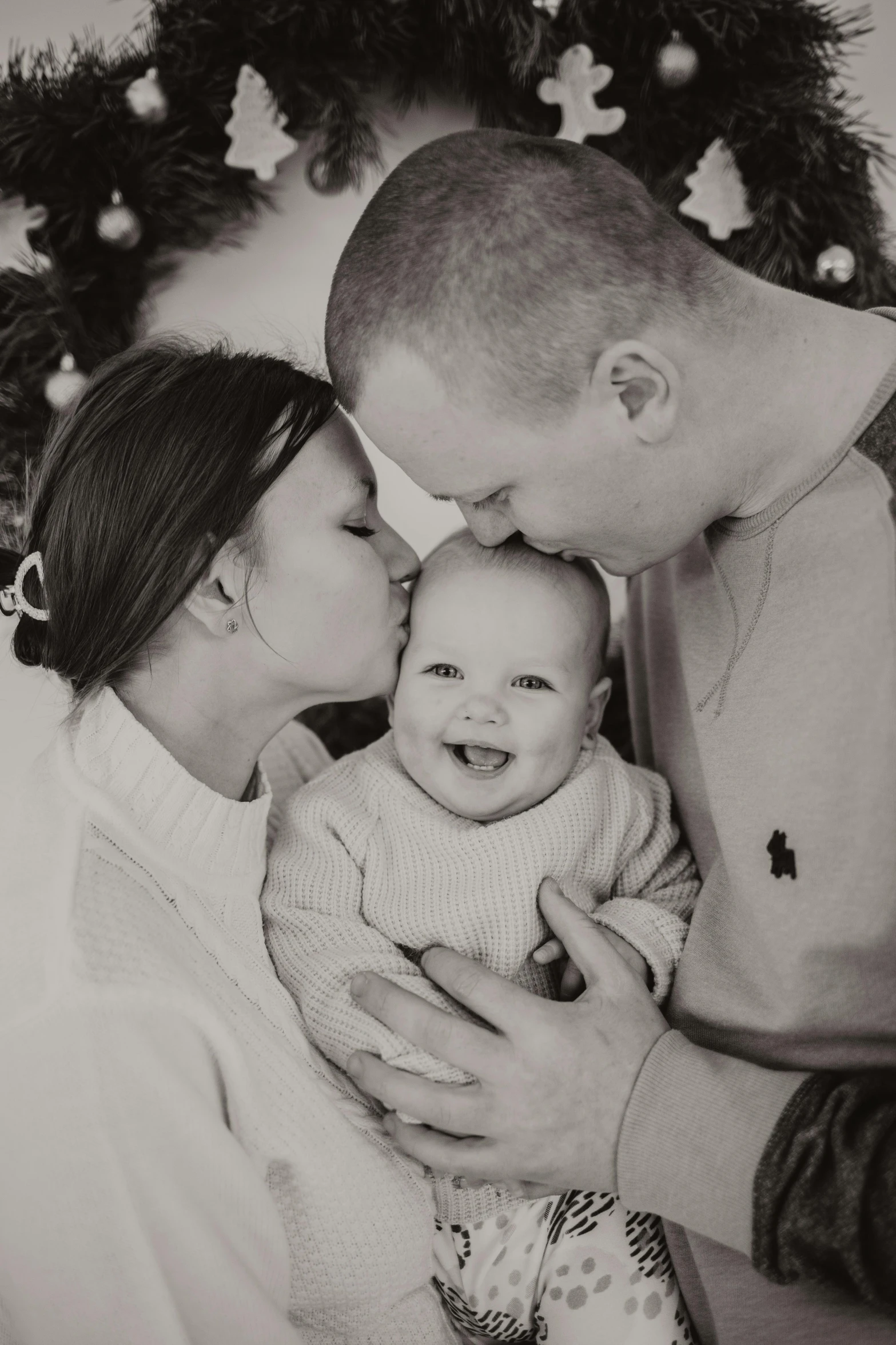 a family with a baby smiles and kisses