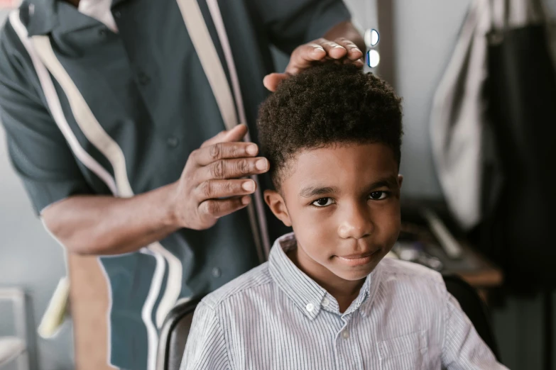 a little boy getting his haircut at the hair salon