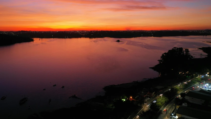 a sunset over the water with several boats on it