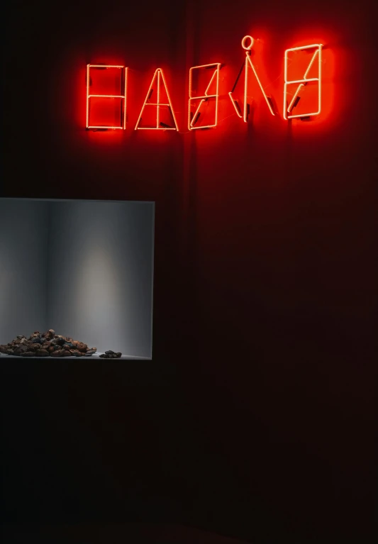 a neon sign above a table and in front of black wall