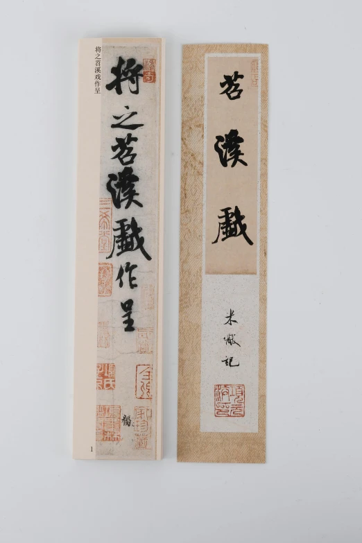 two bookmarks containing an asian calligraphy are next to each other