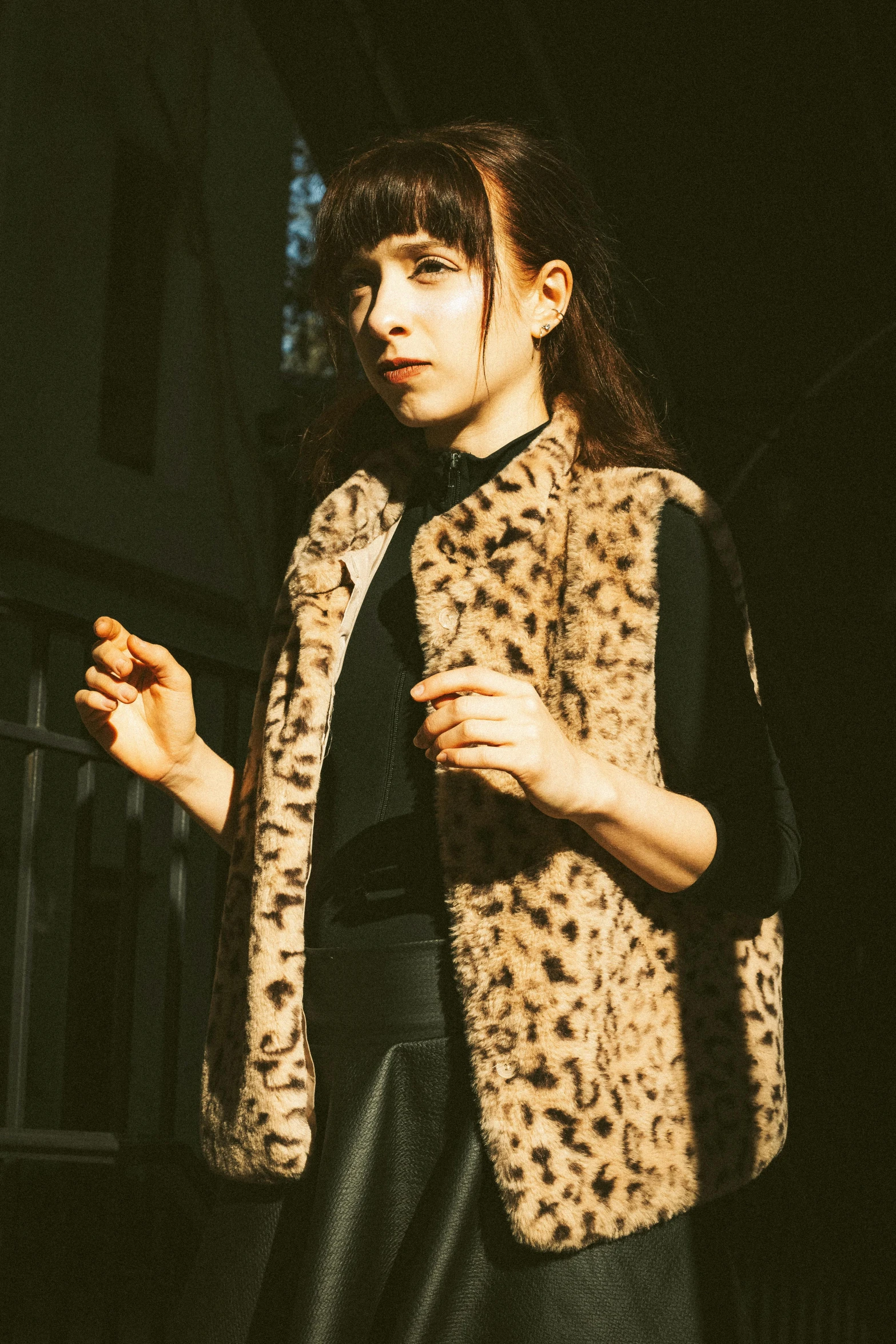 a woman in a leopard print jacket and leather skirt