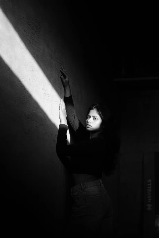 a woman standing in a dark room holding a hand out