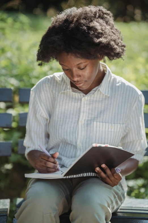 a woman sitting on a bench with a book in her lap