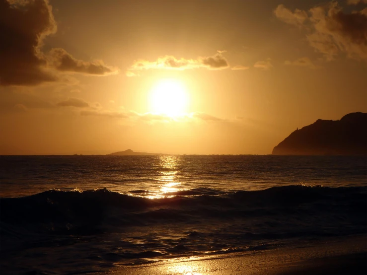 the sun is setting over a small island in the ocean