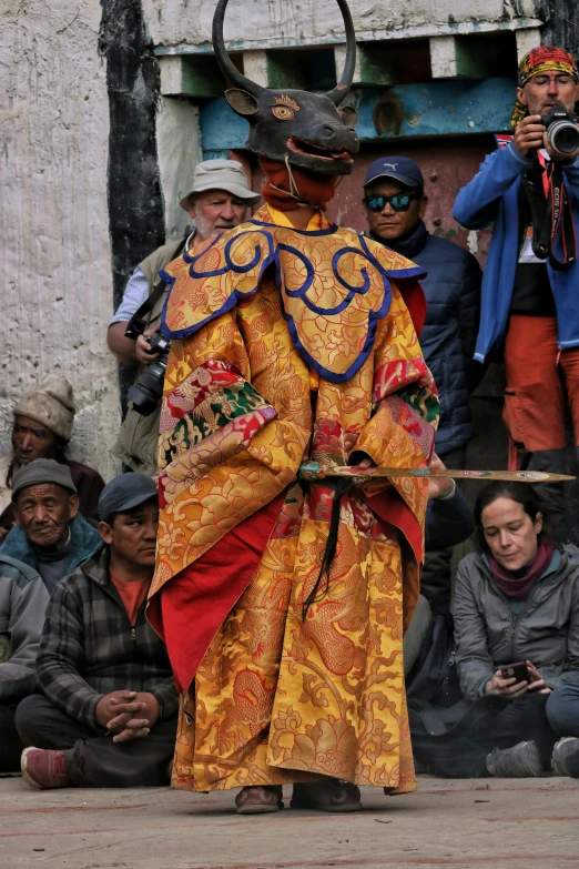 men dressed in colorful costumes standing next to a woman