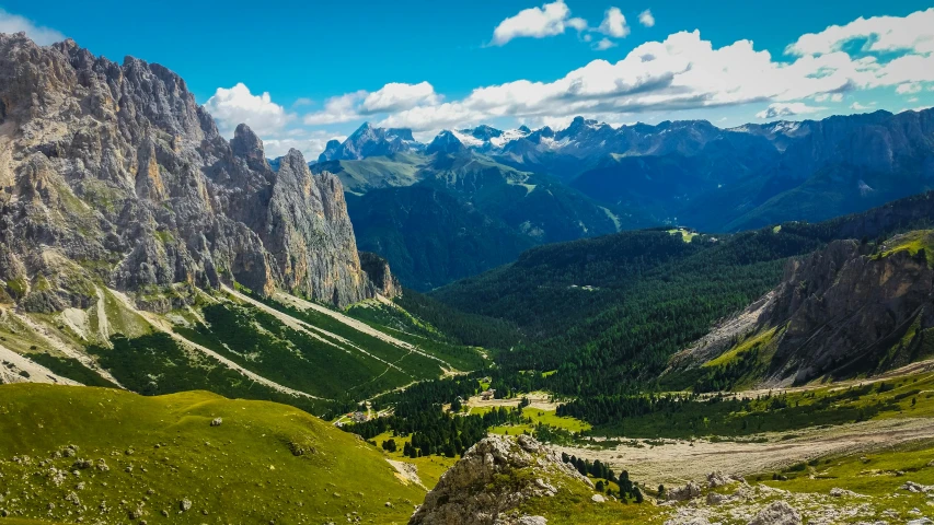 a lush green mountain forest sitting next to a tall steep hill