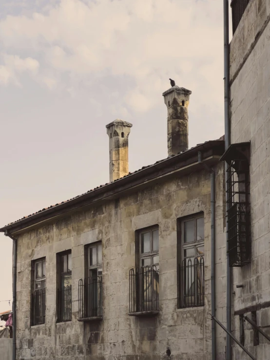 three chimneys are seen on top of two old buildings