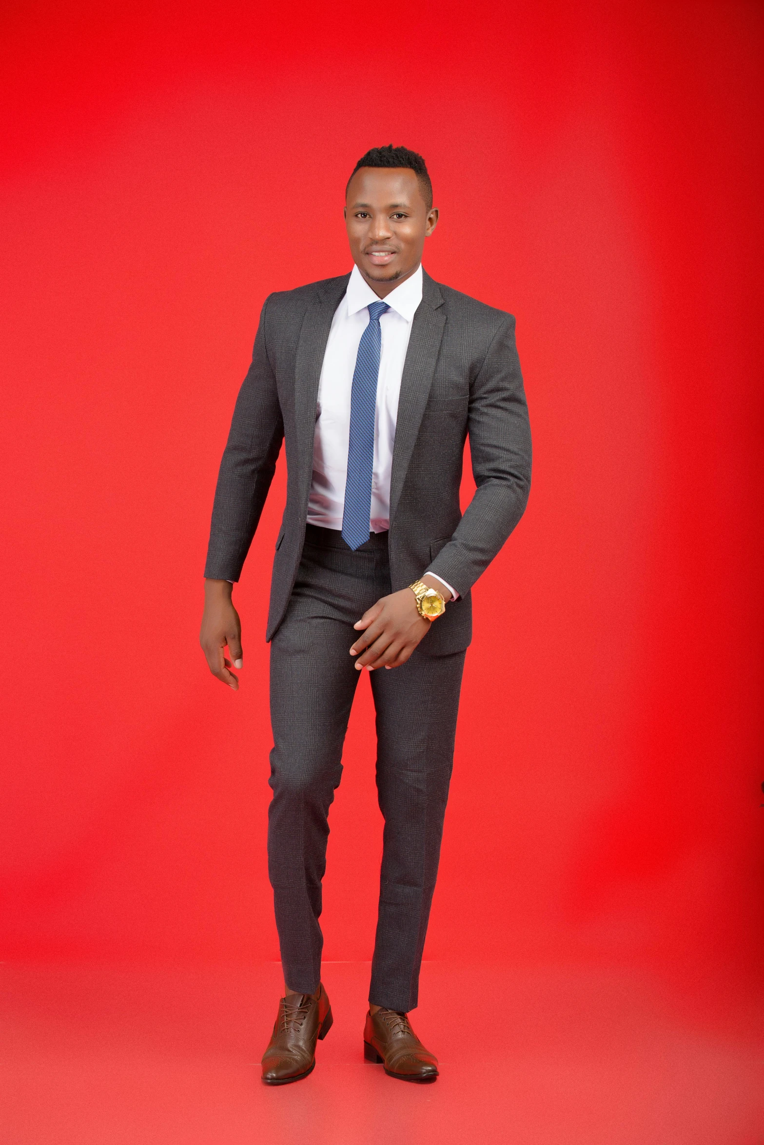 a black man wearing a suit, tie, and shoes