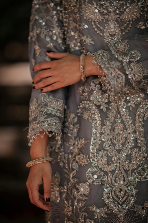 a woman's hand and some silver jewelry