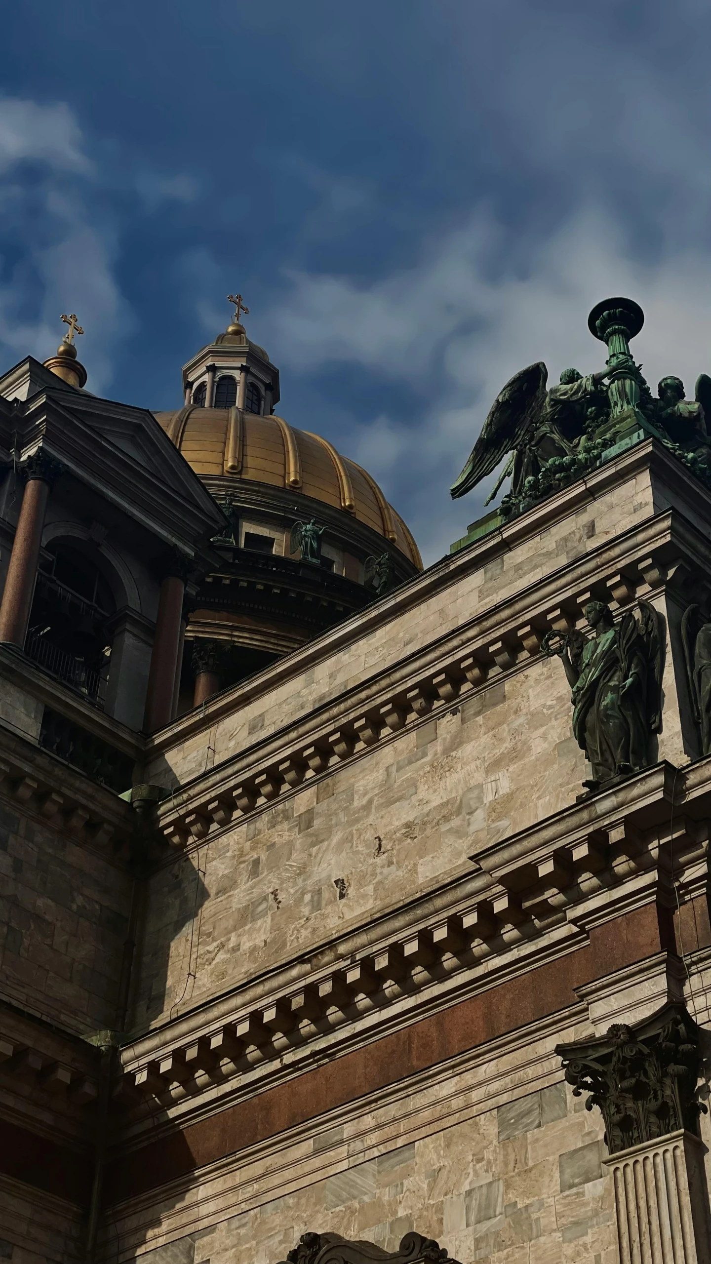 the top of a building with a large statue and a golden dome