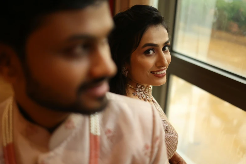 a man and woman looking out a window together